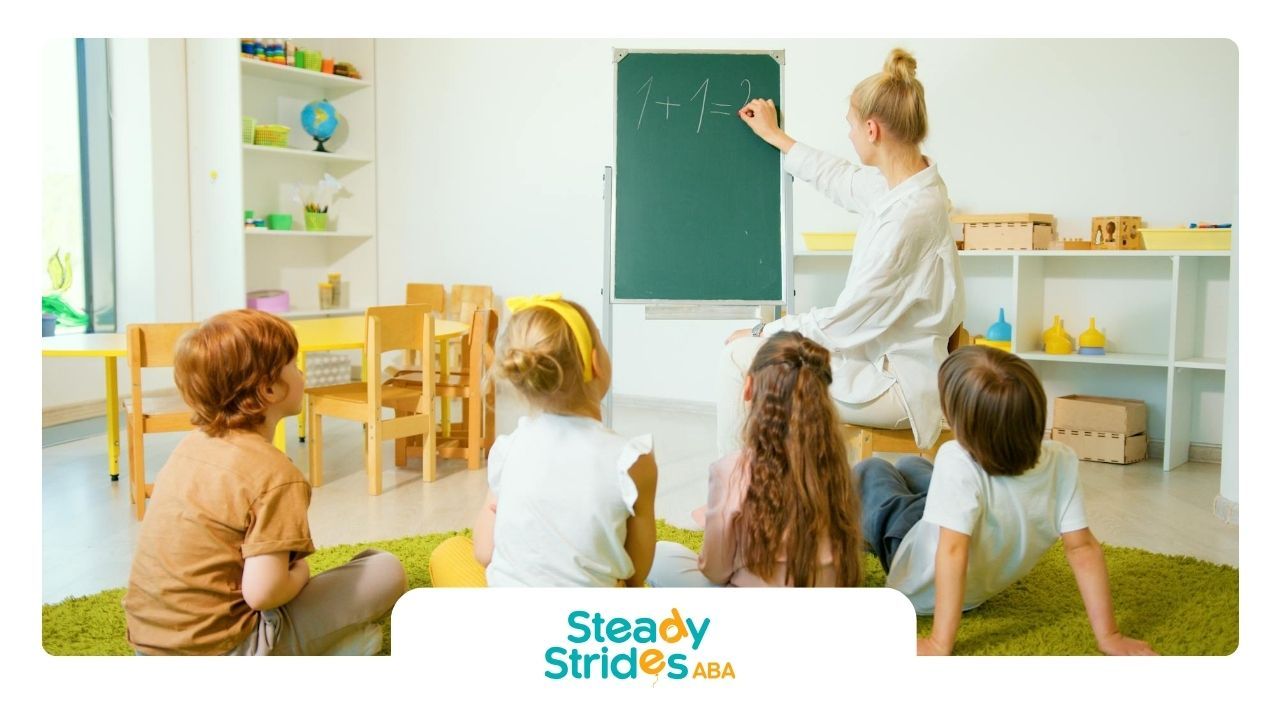 Children with autism learning math in a classroom with an ABA therapist at the blackboard in TX.