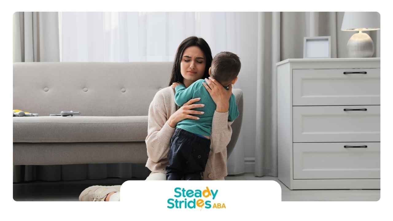 A woman is holding a baby in her arms in a living room.