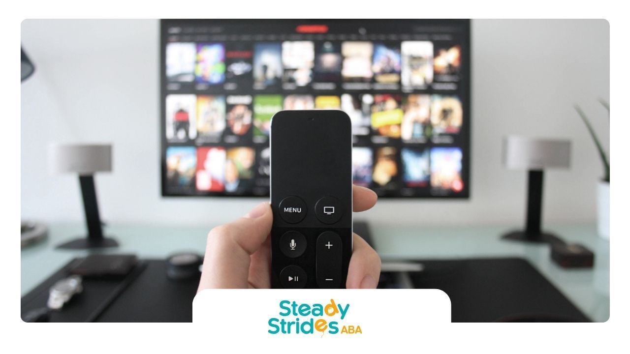 A person is holding a remote control in front of a television ..