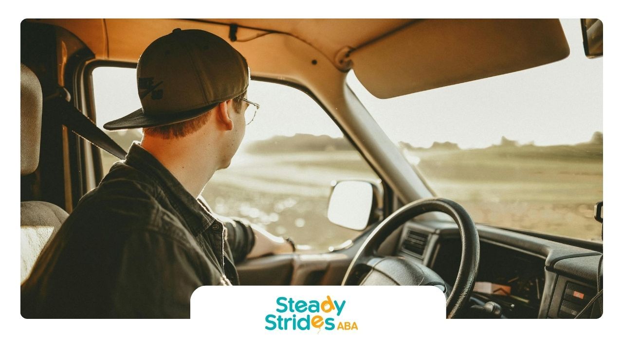 An autistic man in a cap calmly driving in a sunny Texas field and looking out the window of a car.