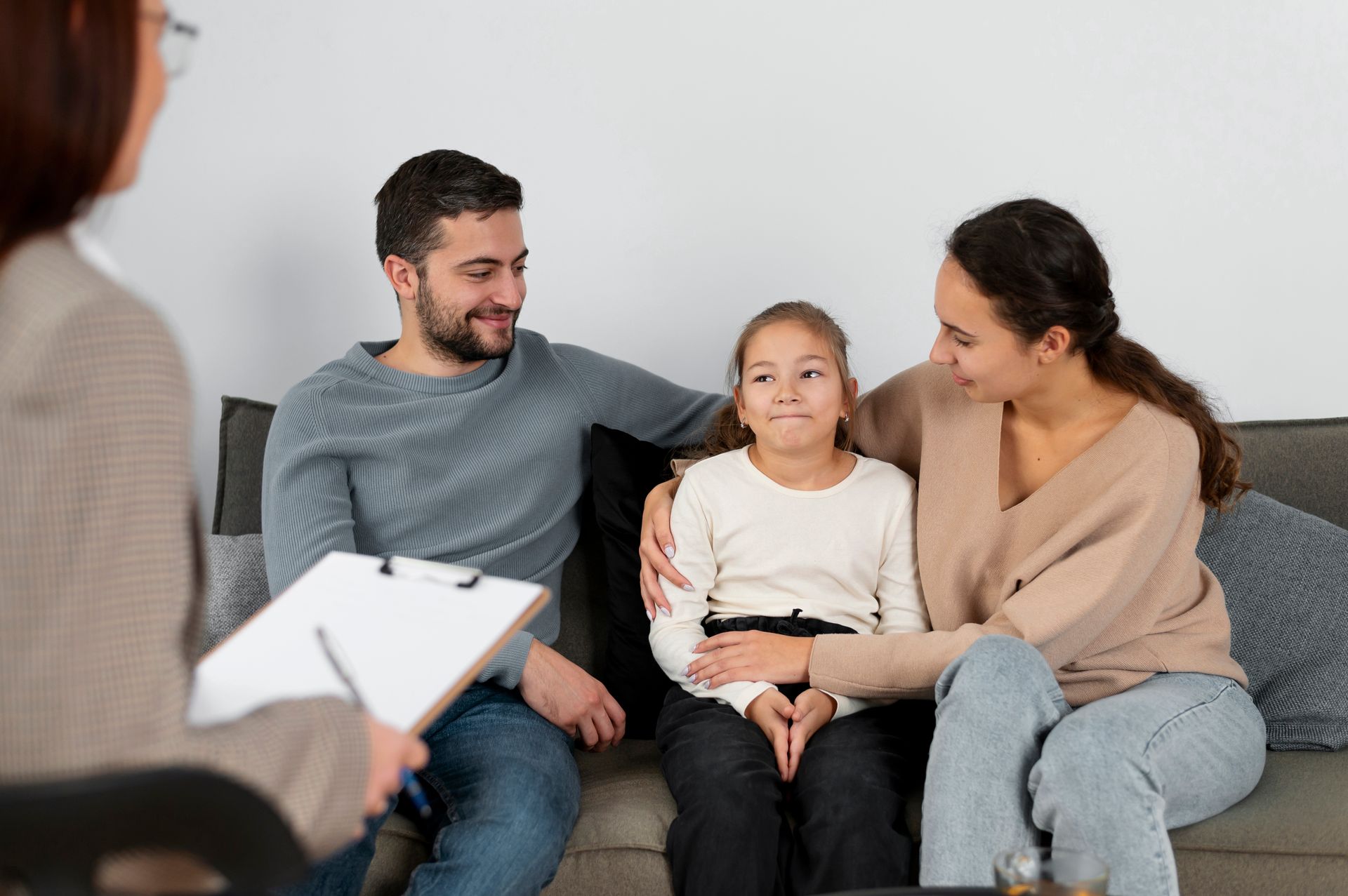 A BCBA specialist educating parents while sitting on a couch