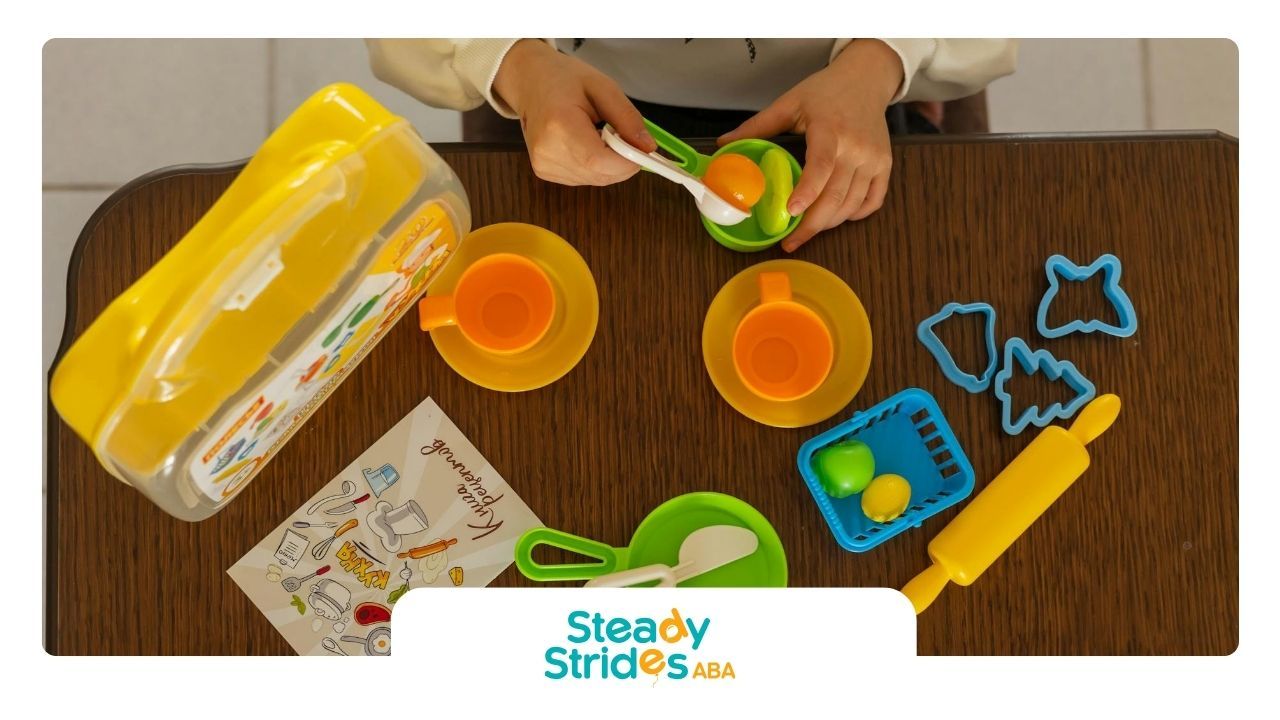Autistic child playing with a toy kitchen set and utensils on a table during ABA therapy in TX.