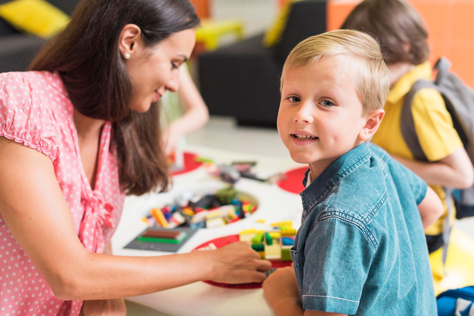 A BCBA specialist playing with a child in school