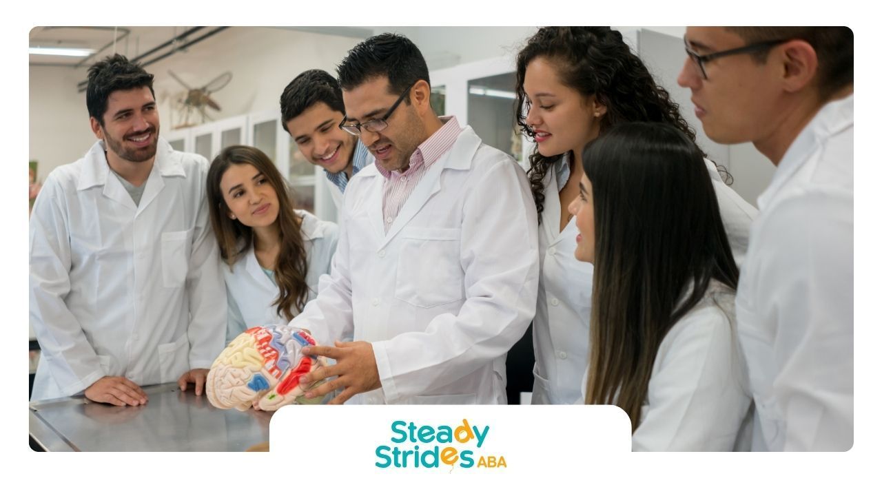 A group of people in lab coats are looking at a model of a brain.