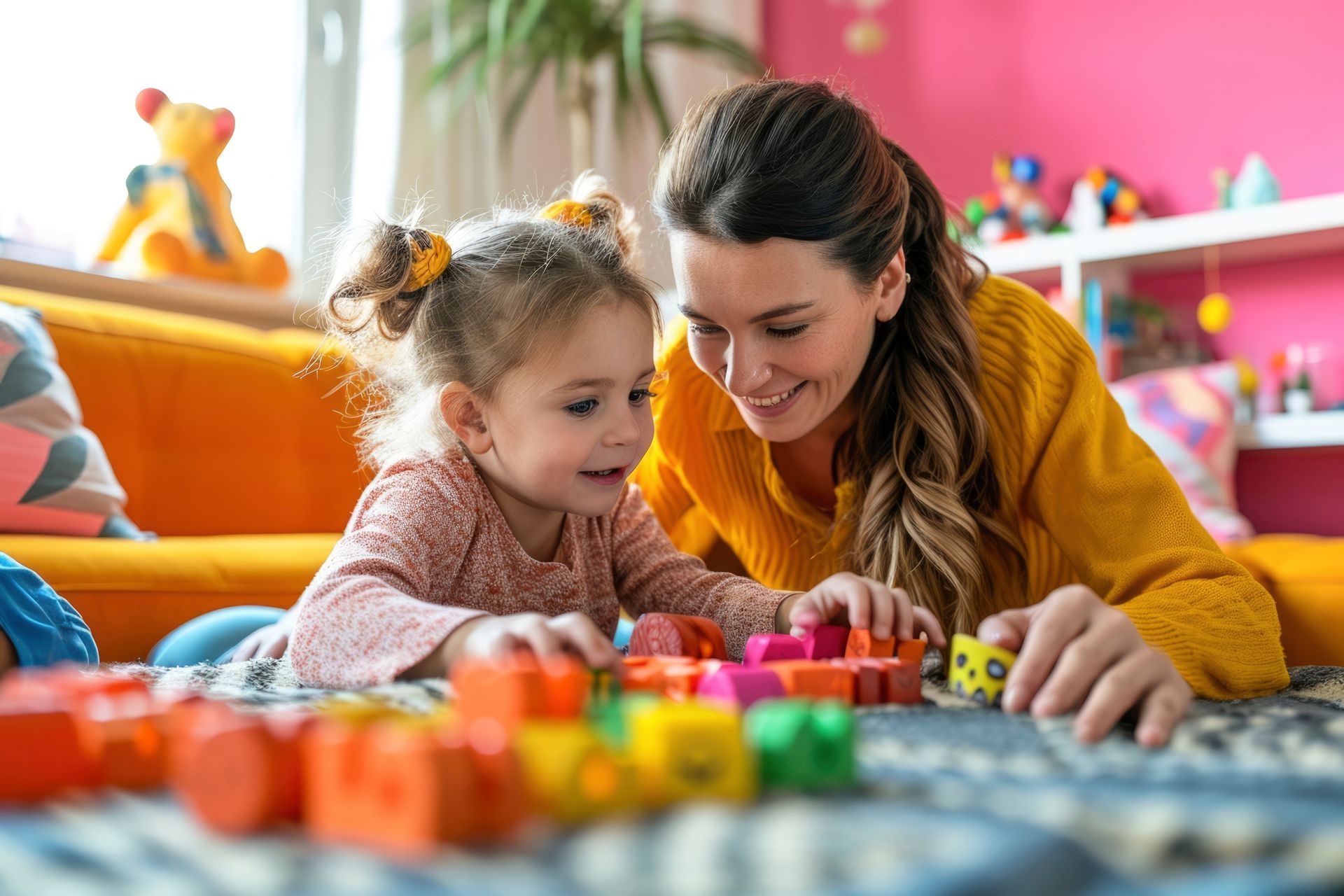 A mother and a child laying on the floor playing with toys