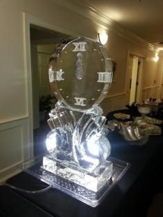 Clear acrylic award sculpture on a lit table in a banquet hall hallway