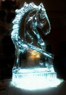 Transparent ice sculpture of a horse head on a glowing base, lit blue against a dark background