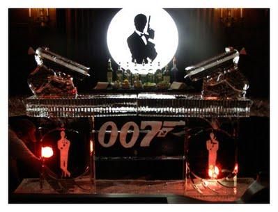 James Bond-themed display with 007 logo, pistols, and glowing red lights on a dark stage