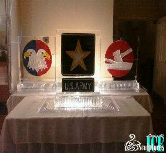 Clear acrylic award display with a U.S. Army star plaque centered between two circular emblems on a table.