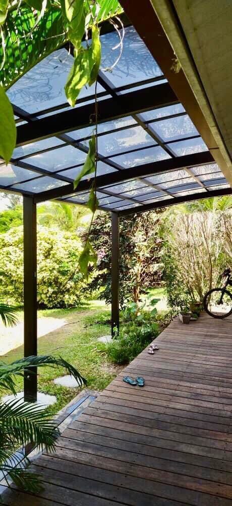 Une terrasse en bois avec un vélo garé sous une pergola.