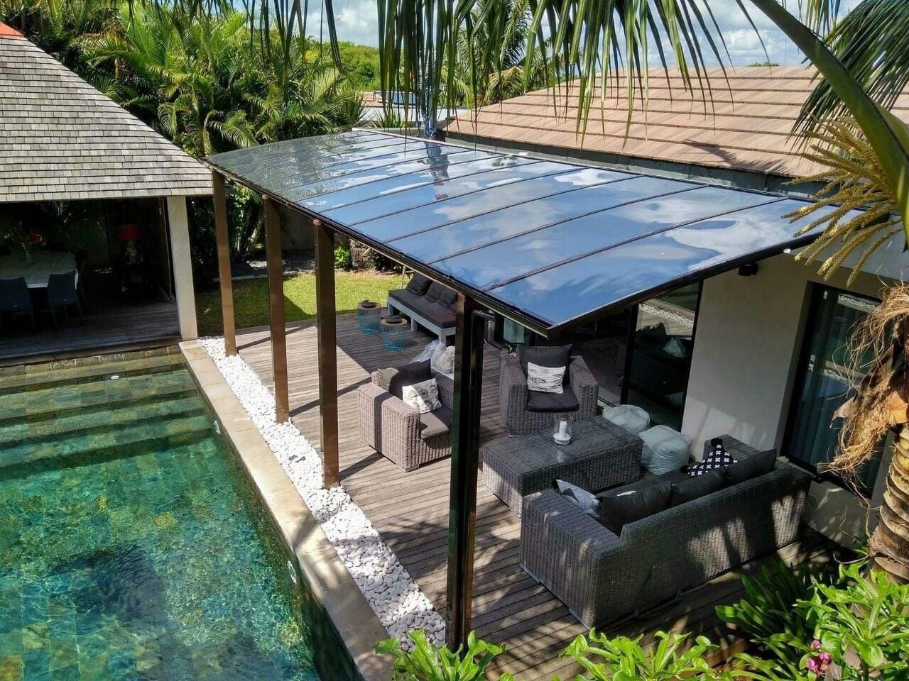 Une vue aérienne d'une maison avec un patio couvert à côté d'une piscine.