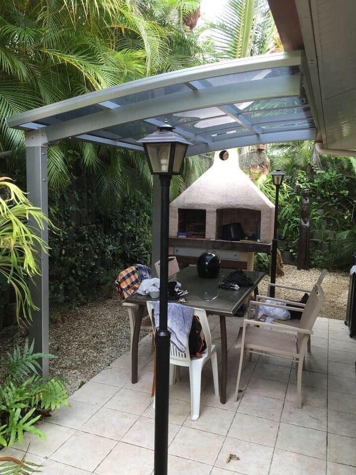 Un patio avec une table et des chaises sous un auvent.