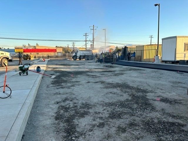 Construction site with equipment and a truck, preparing a parking lot.
