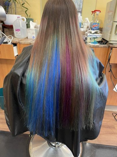 A woman is getting her hair dyed in a salon.