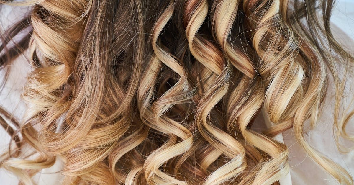 A close up of a woman 's curly hair on a white surface.