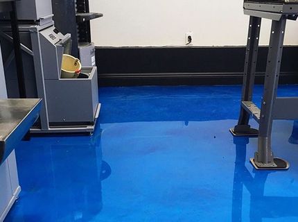 A blue floor in a room with a machine on it.