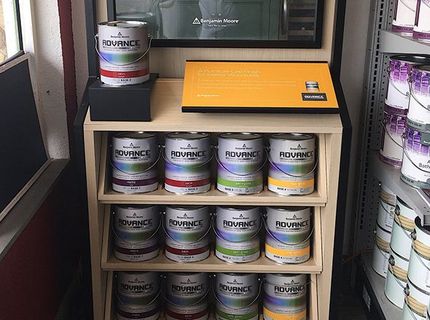 A display of paint cans on a shelf in a store.