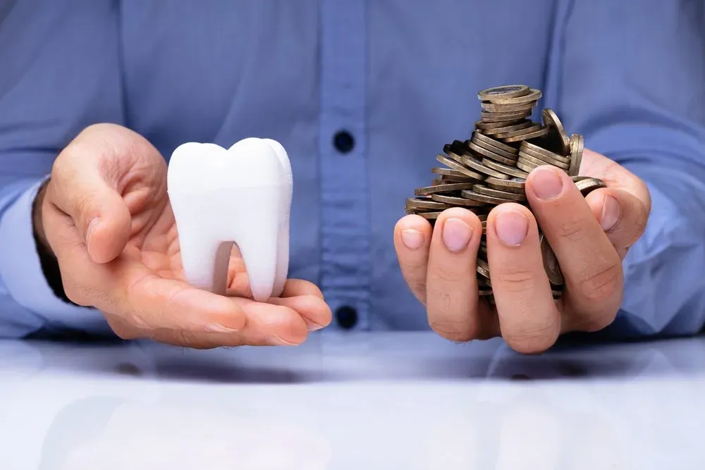 Man Holding Tooth And Coins