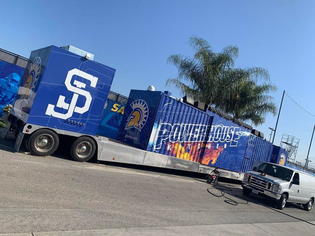 A truck with a trailer attached to it is parked on the side of the road.