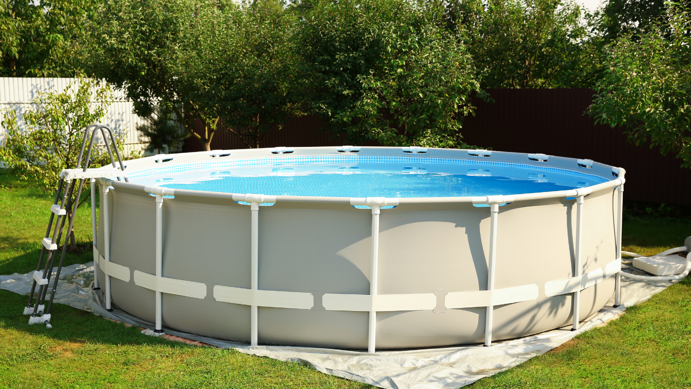 Round above-ground swimming pool filled with blue water, set in a backyard.