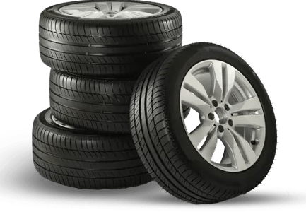 Four car tires stacked, one leaning against the stack.