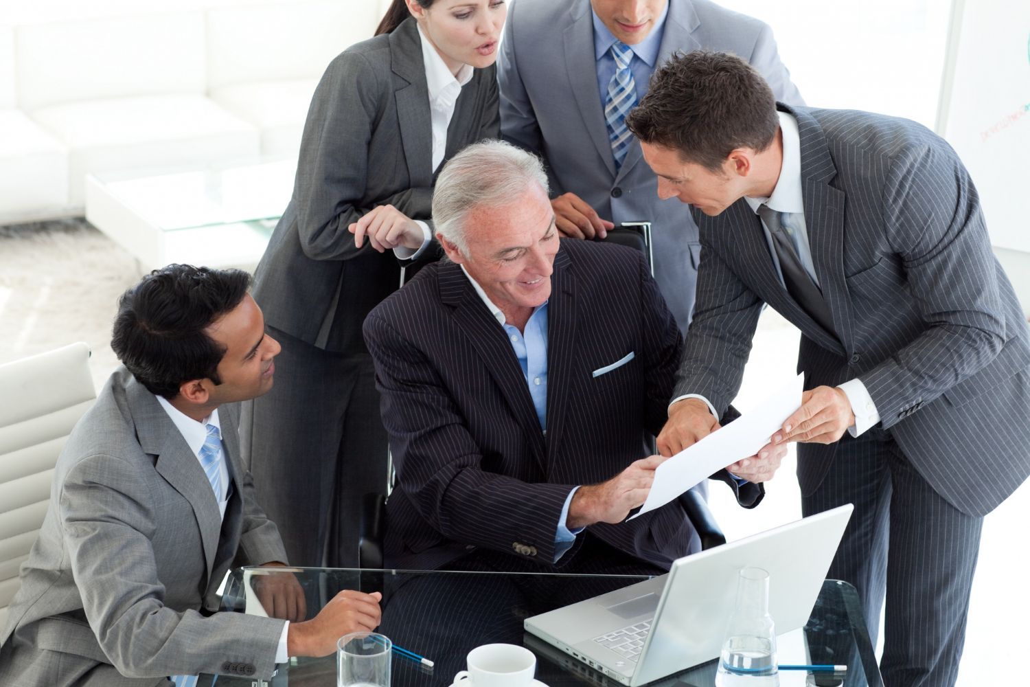 Business colleagues reviewing documents together at a table, smiling.