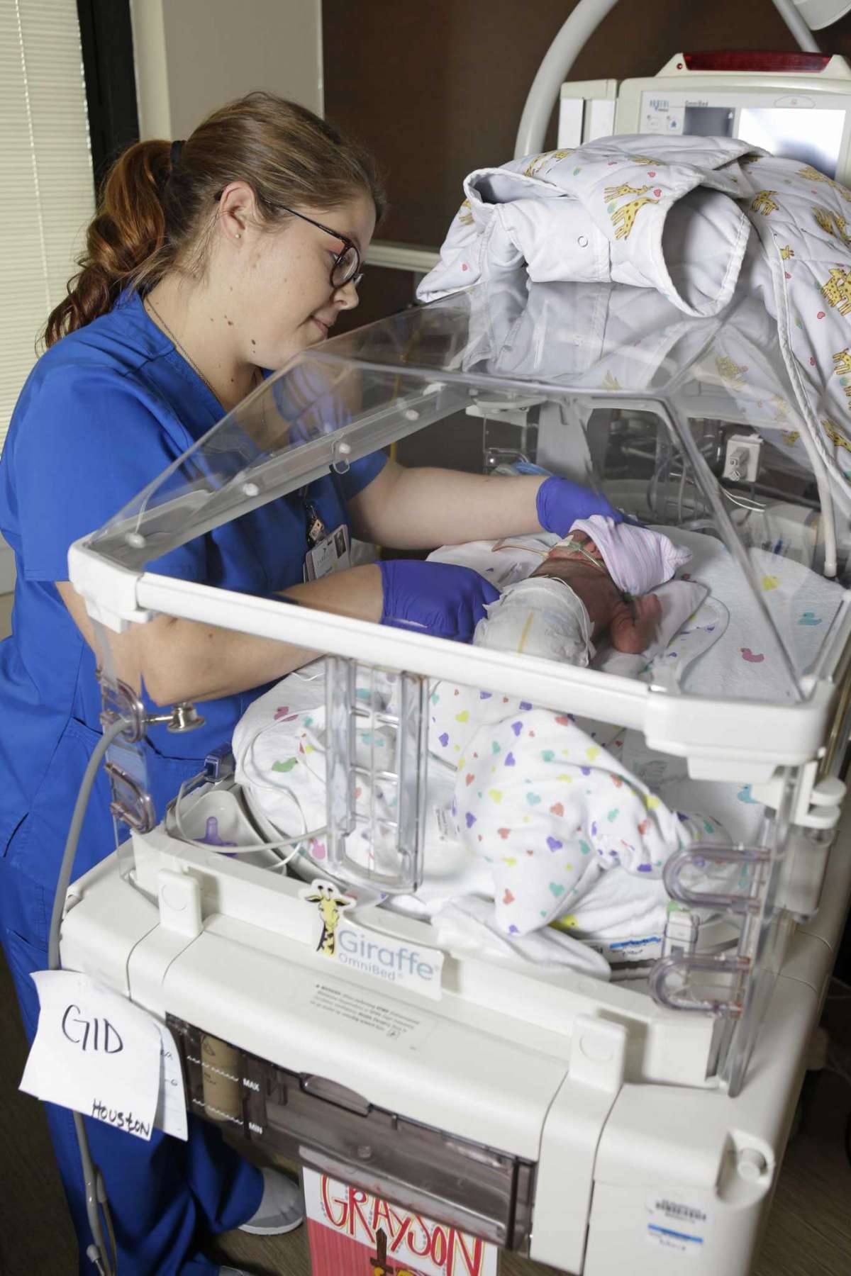 nurse at baby bedside in hospital