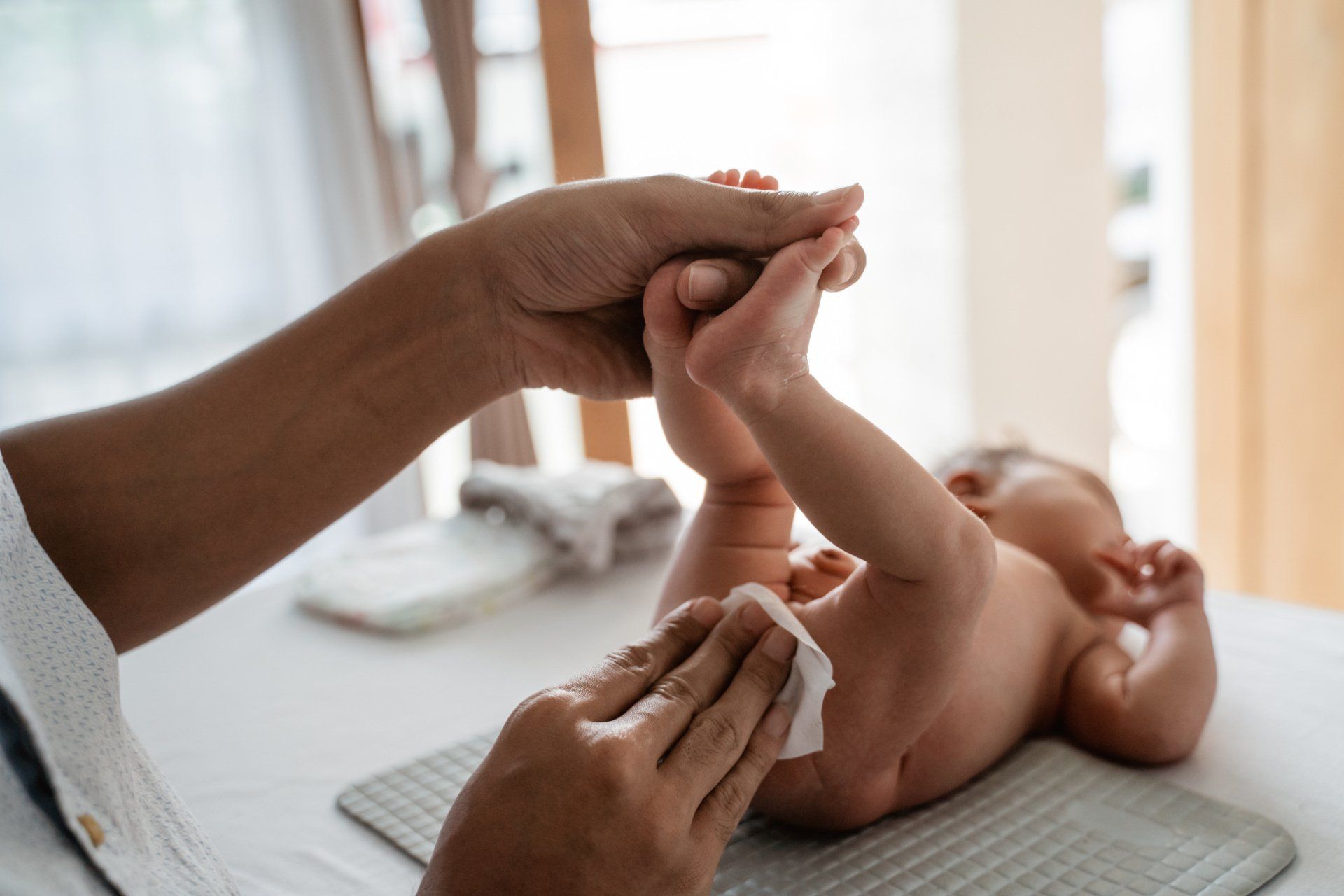 dad using baby wipe to change diaper