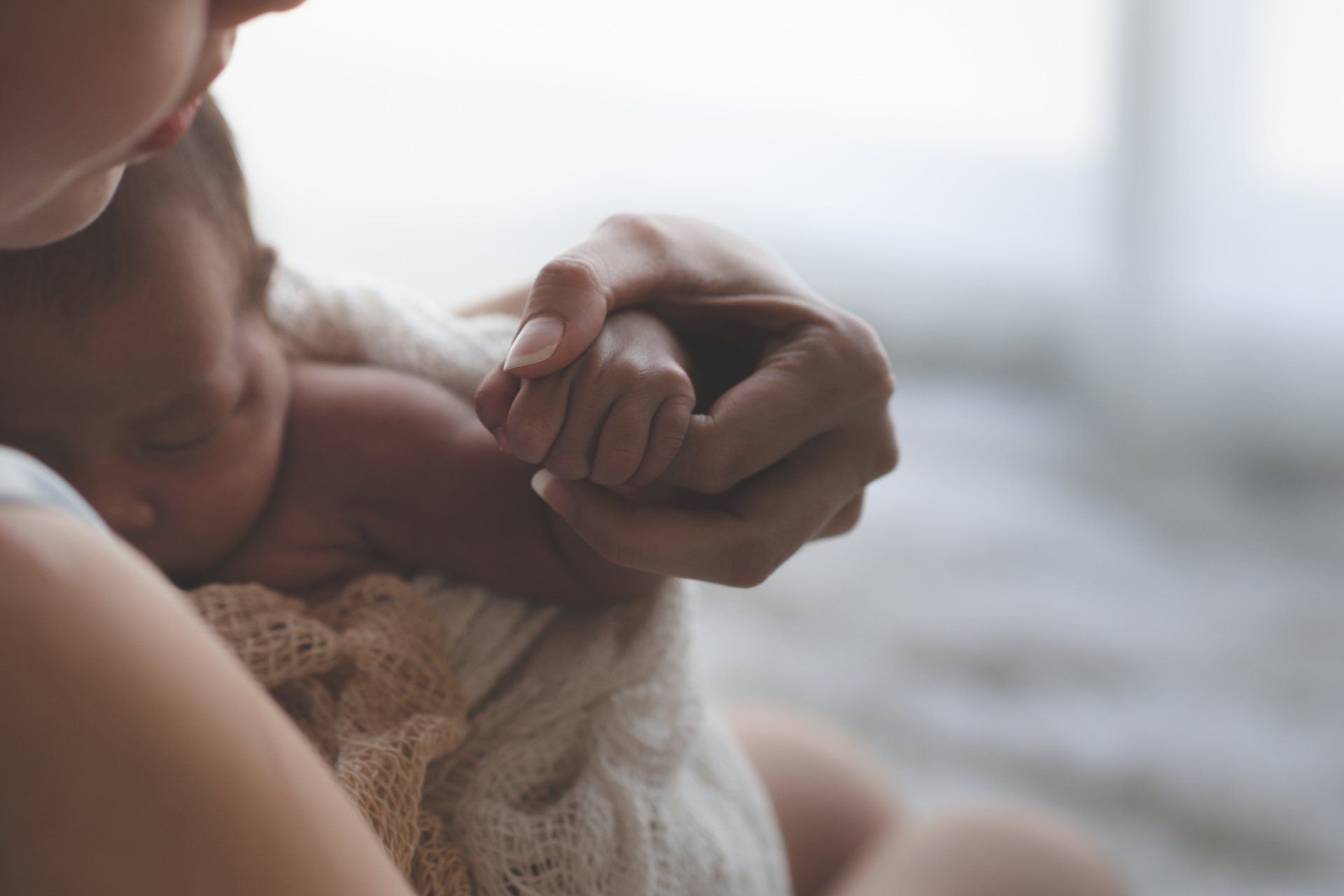 mom holding newborn hand