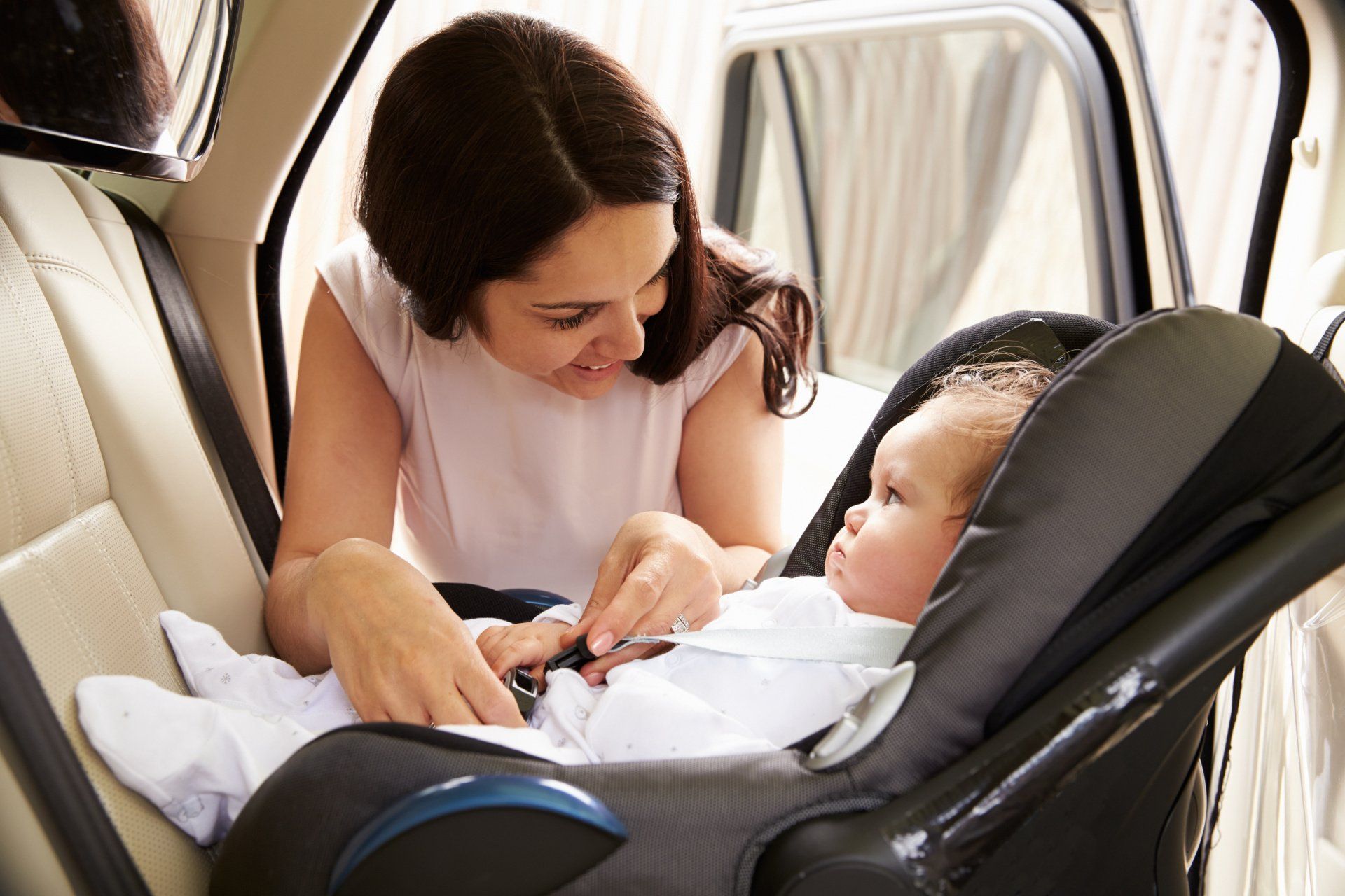 mom buckling baby in car