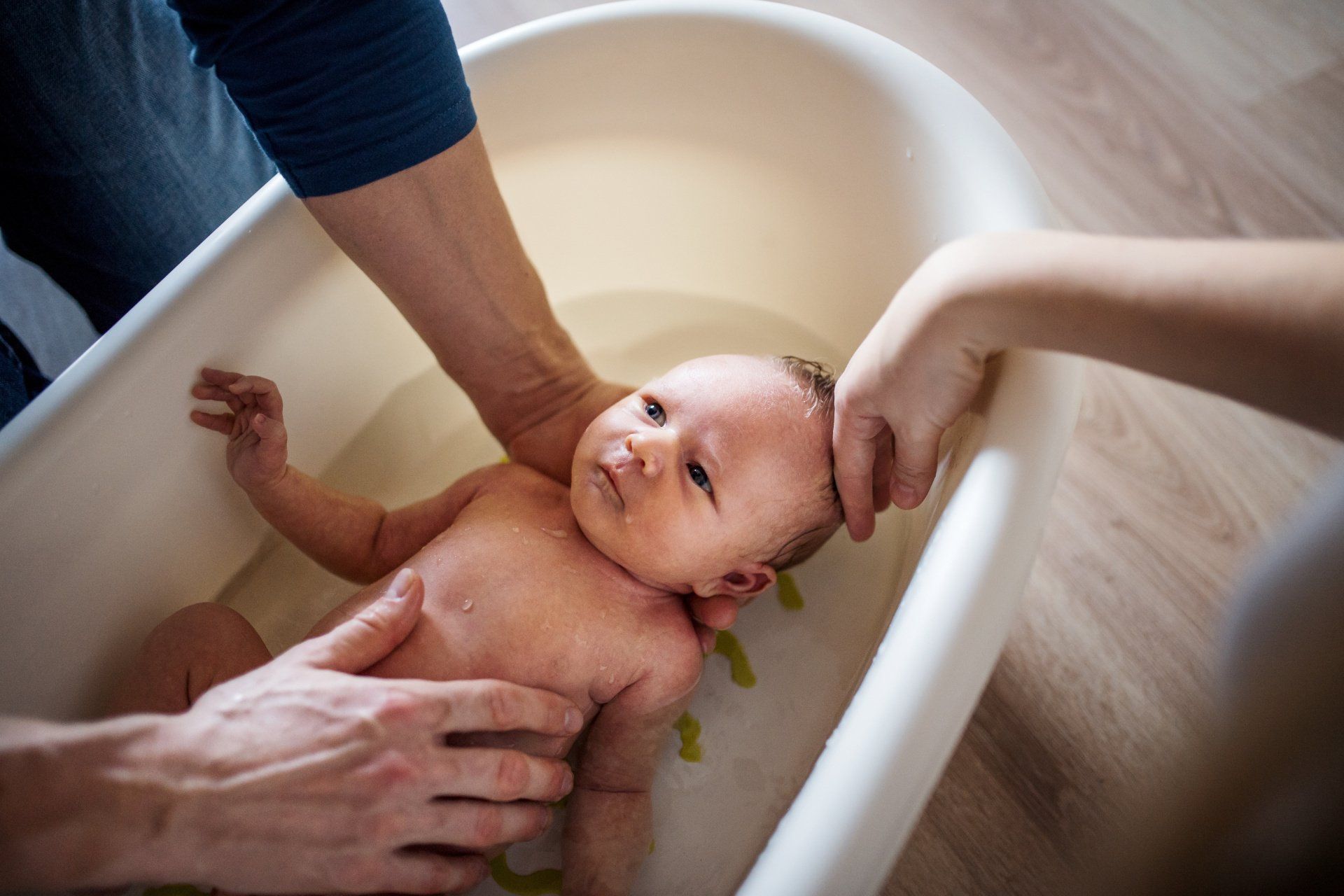 newborn baby in bathtub with parents