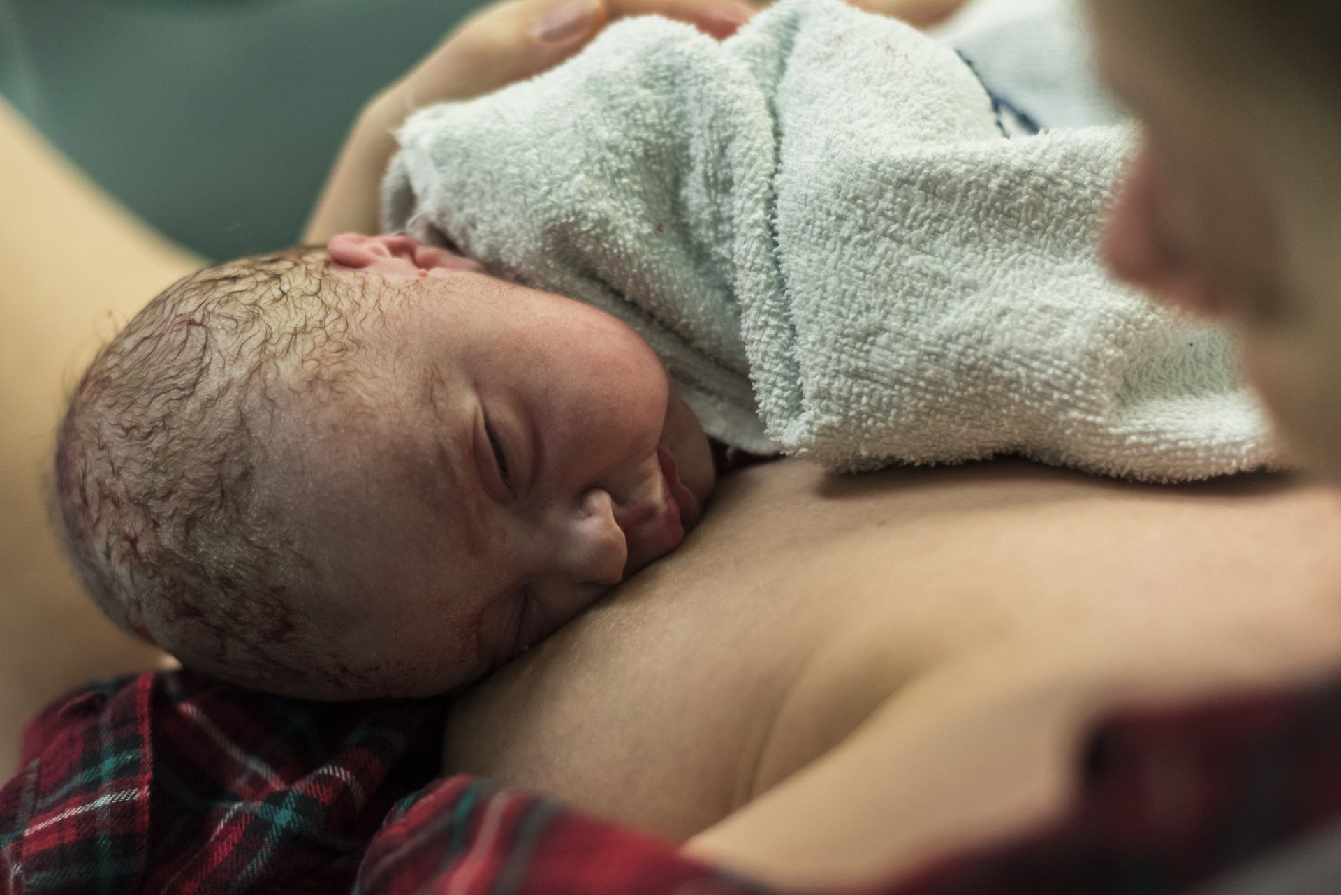 mom holding newborn baby on chest