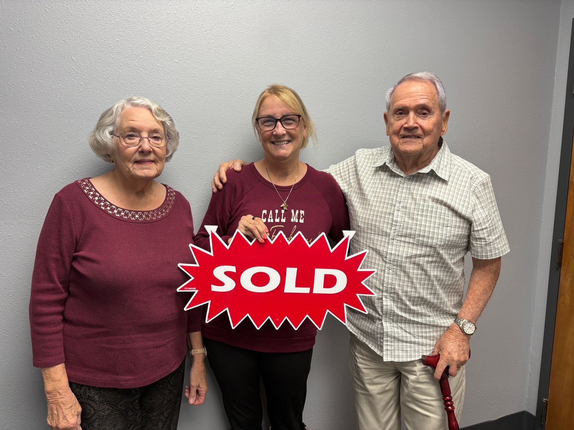 Three people stand with a 