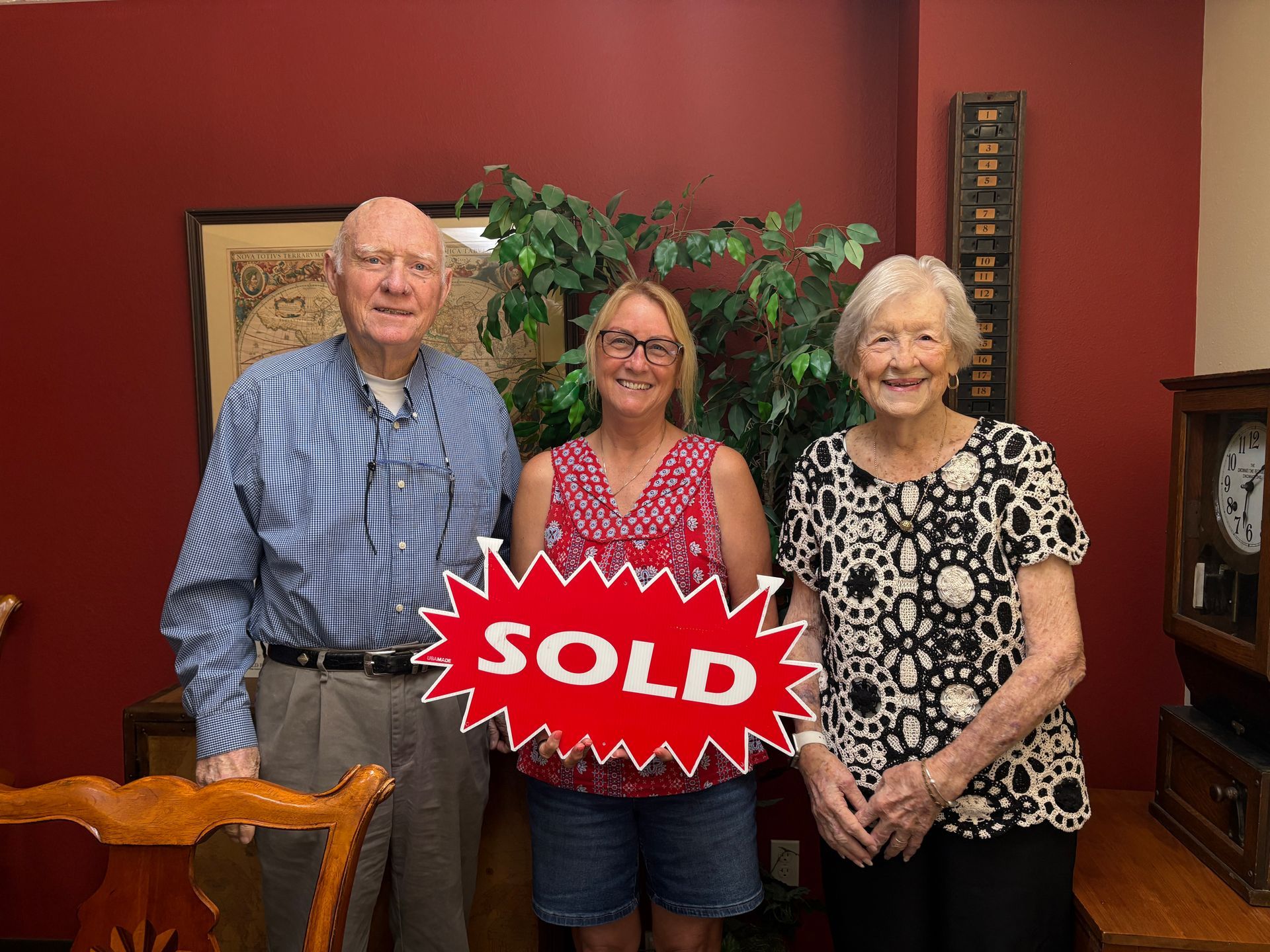 Two older adults and a woman holding a 