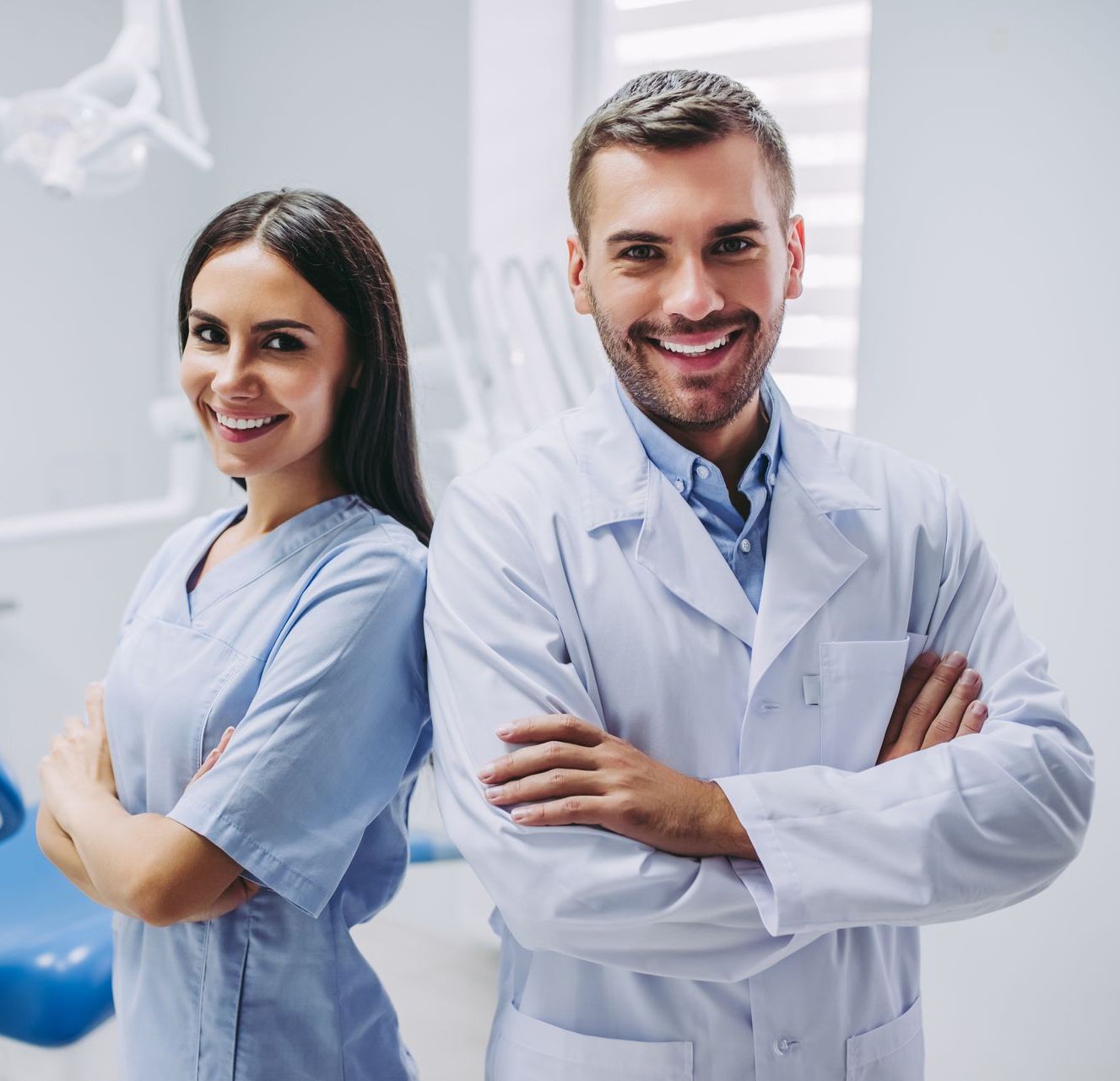 A man and a woman are posing for a picture in a dental office.