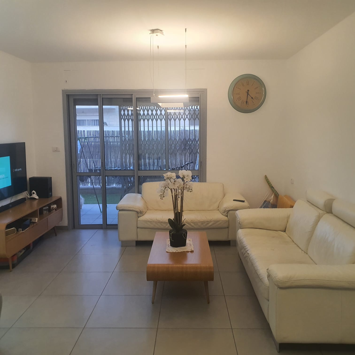 סלון עם ריהוט לבן ושעון על הקיר