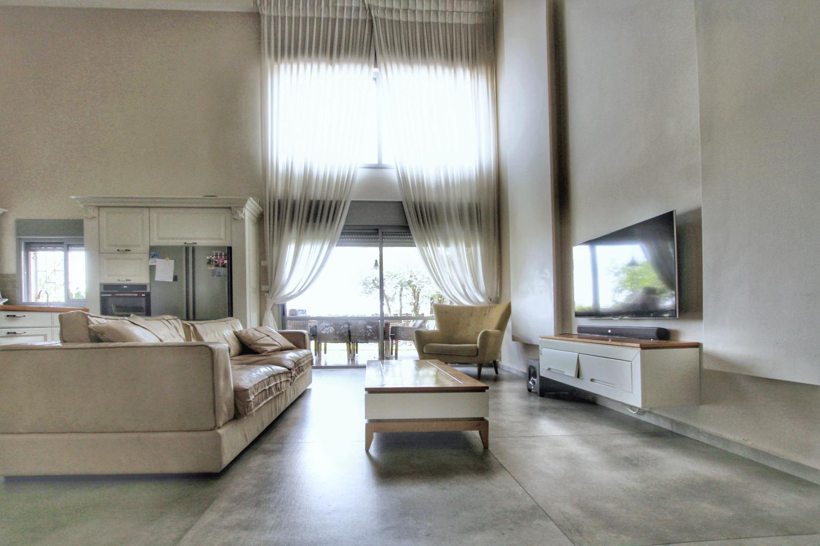 סלון עם ספה, כיסא, שולחן קפה וטלוויזיה.