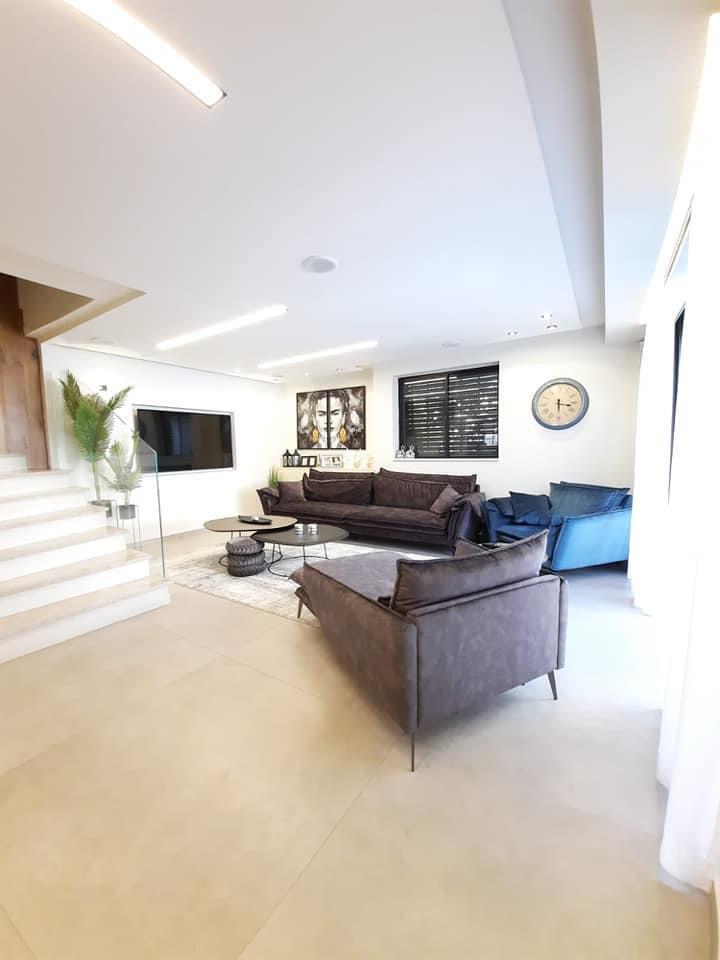 סלון מלא ברהיטים ושעון על הקיר.