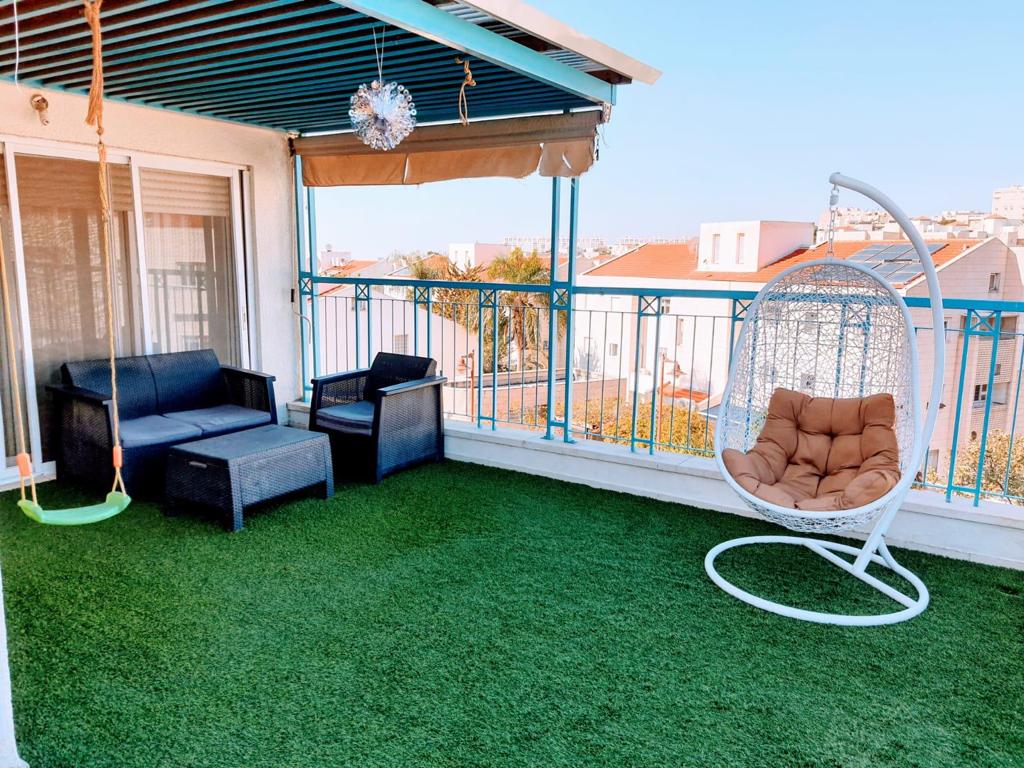 מרפסת עם ספה, כיסאות ונדנדה.