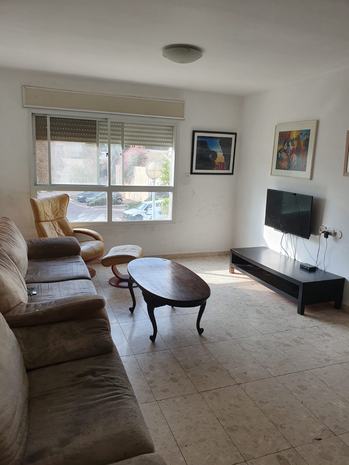 סלון עם ספה, כיסא, שולחן קפה וטלוויזיה.