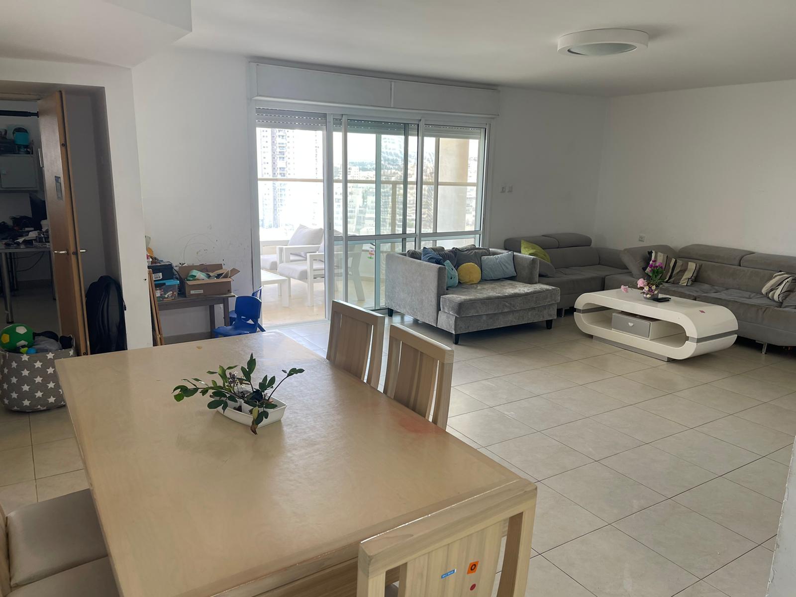 סלון עם שולחן וכיסאות וספה.