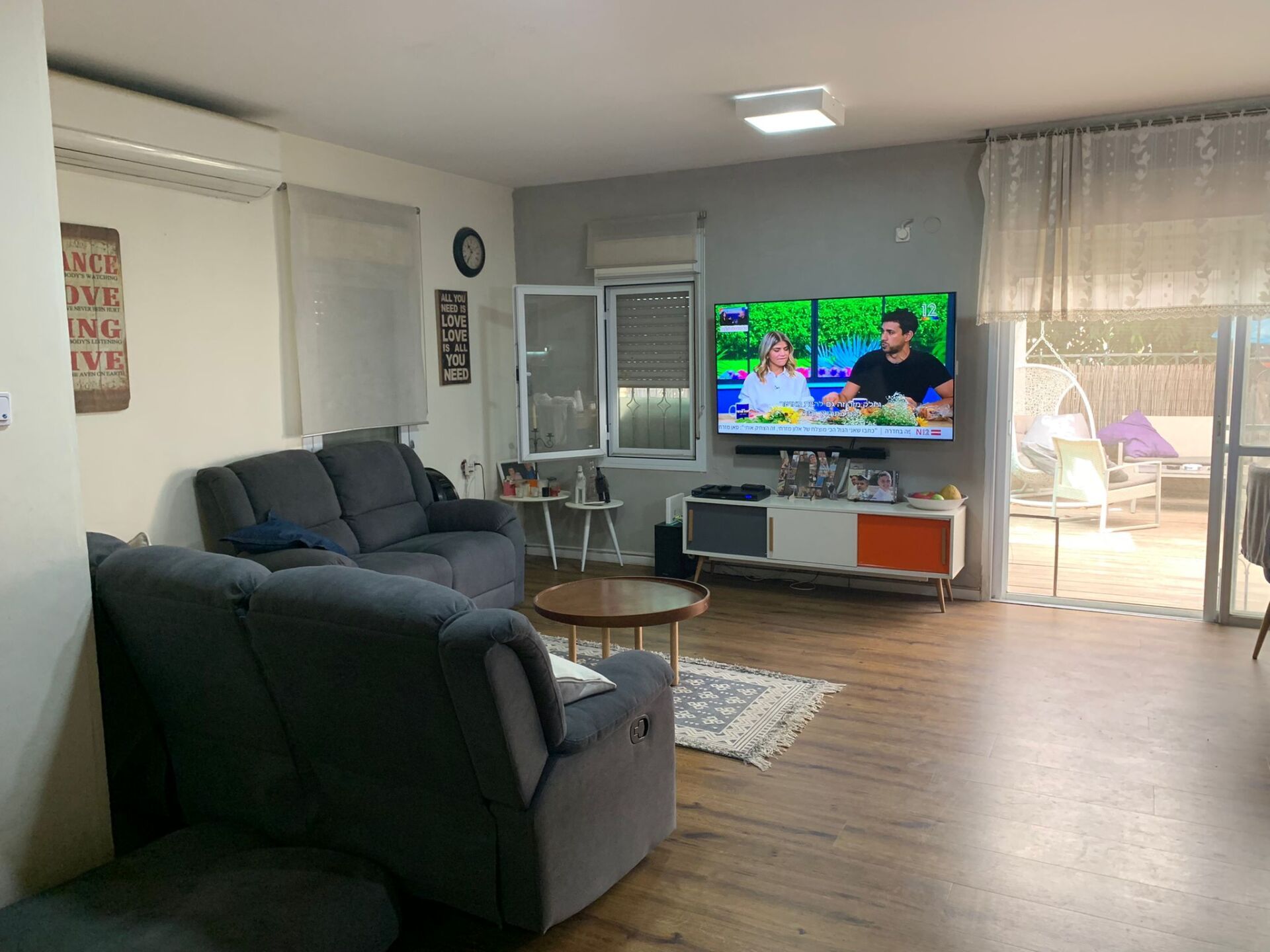 סלון מלא ברהיטים וטלוויזיה בעלת מסך שטוח.