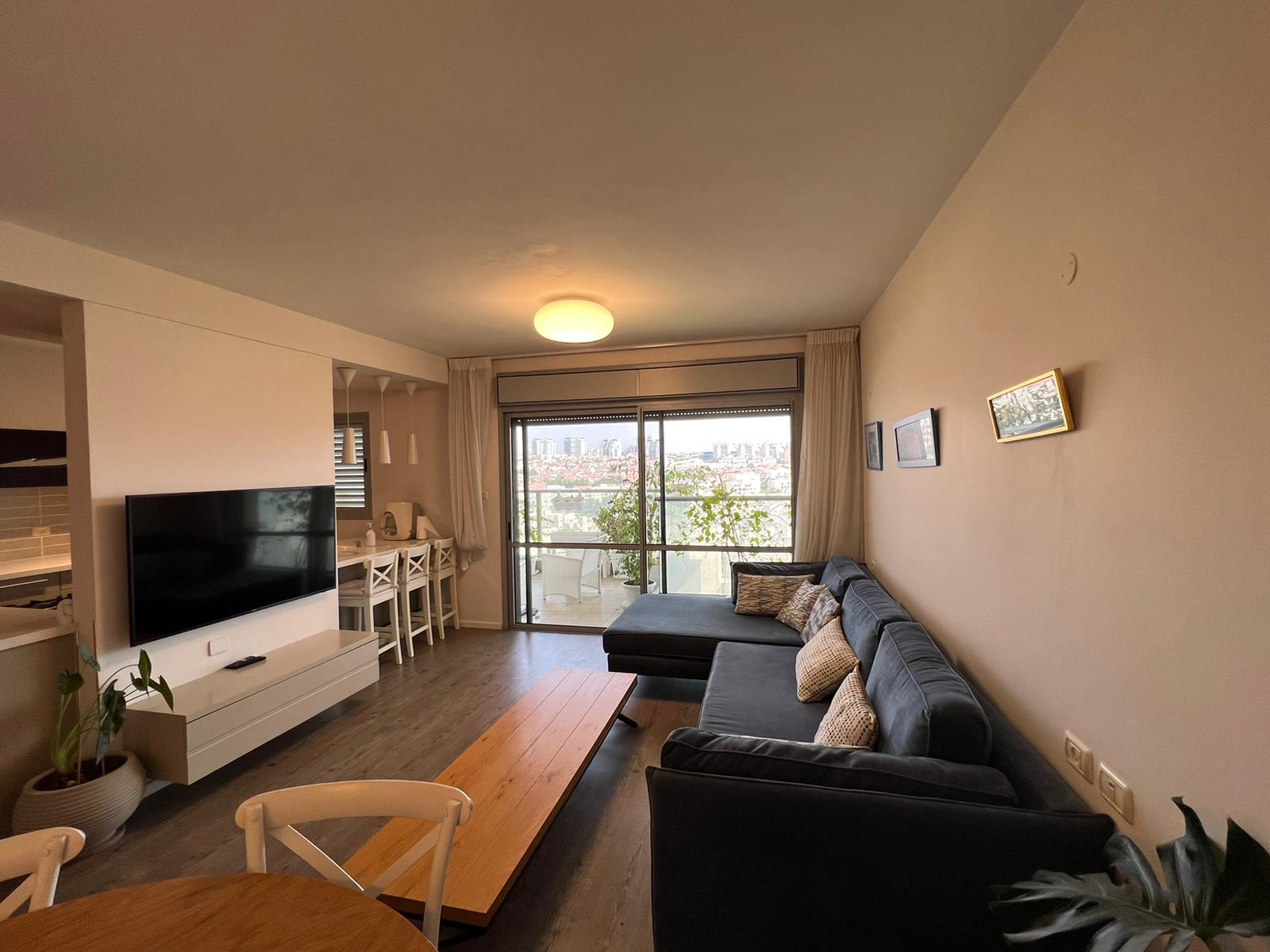 סלון עם ספה, טלוויזיה, שולחן וכיסאות.