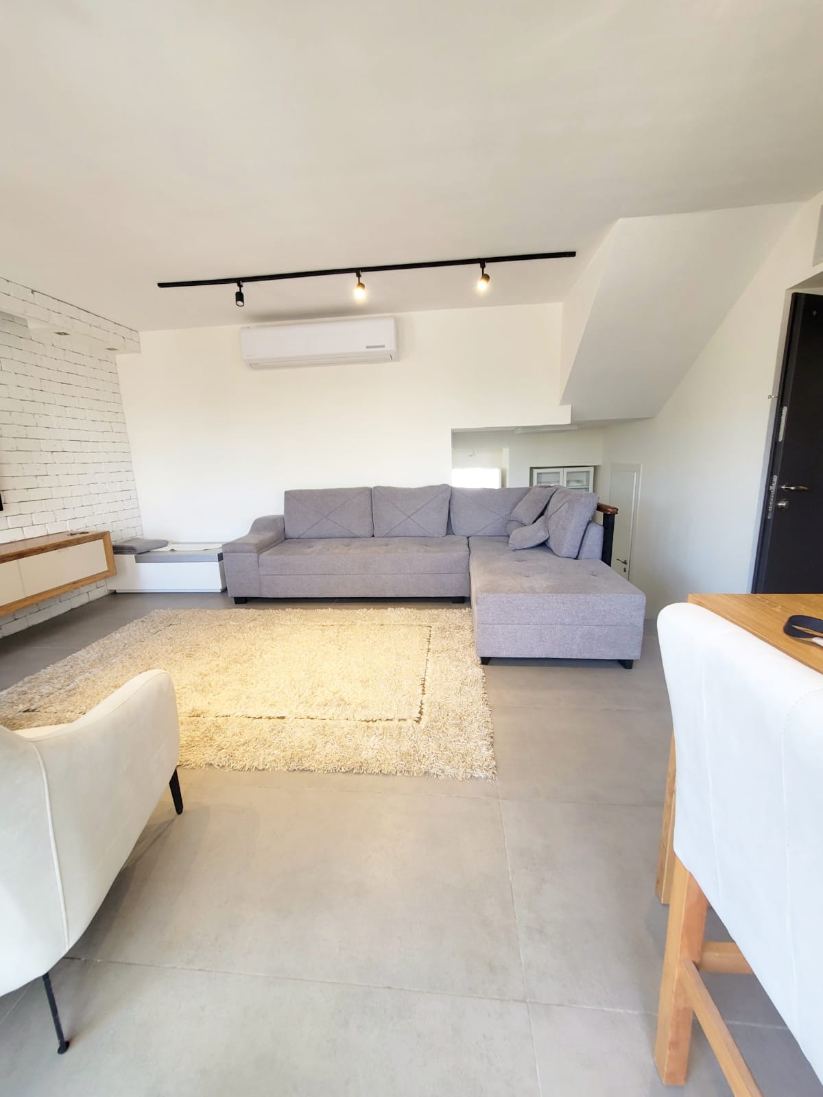 סלון עם ספה, כיסא, שולחן ושטיח.