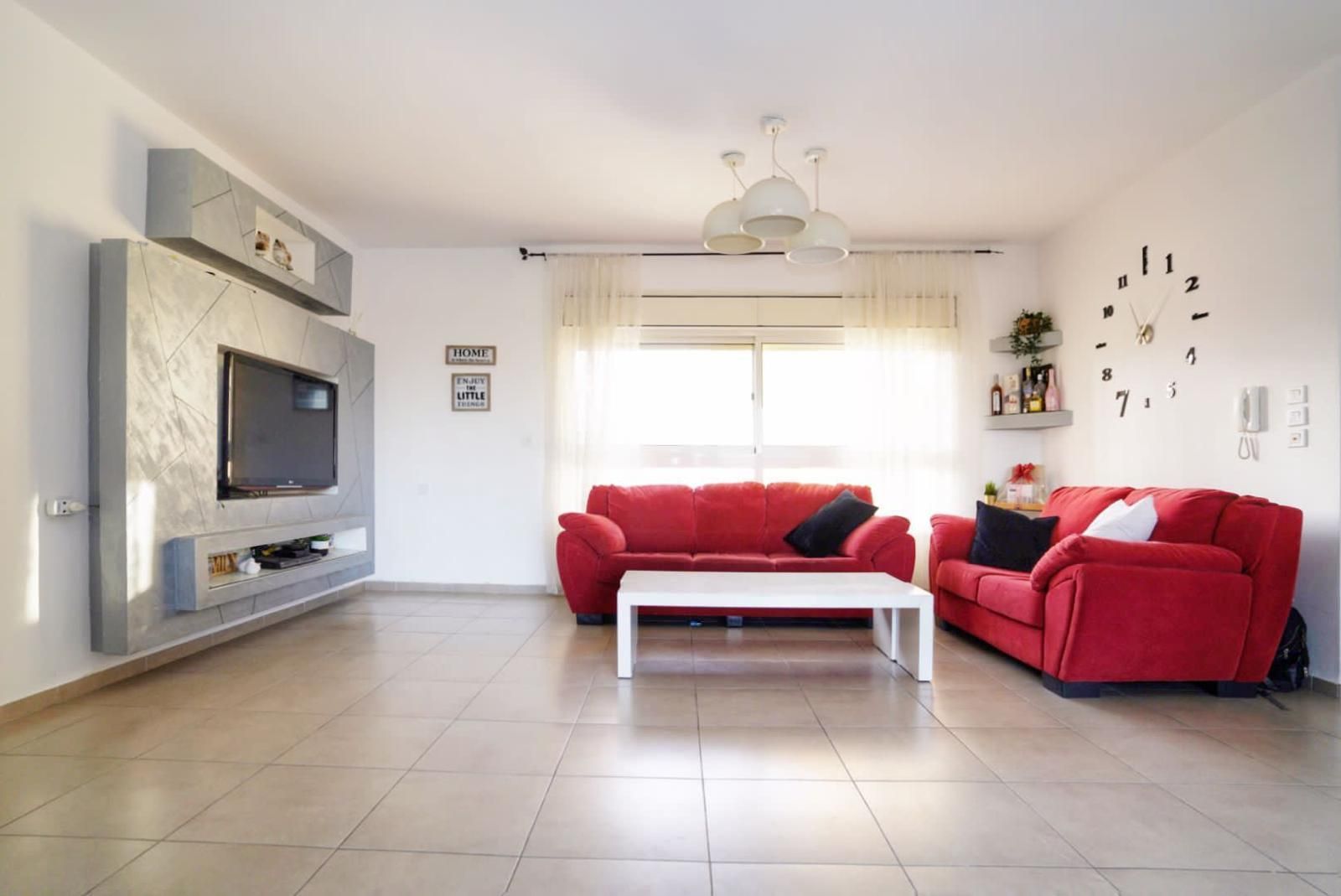 סלון עם ספה אדומה ושולחן קפה לבן