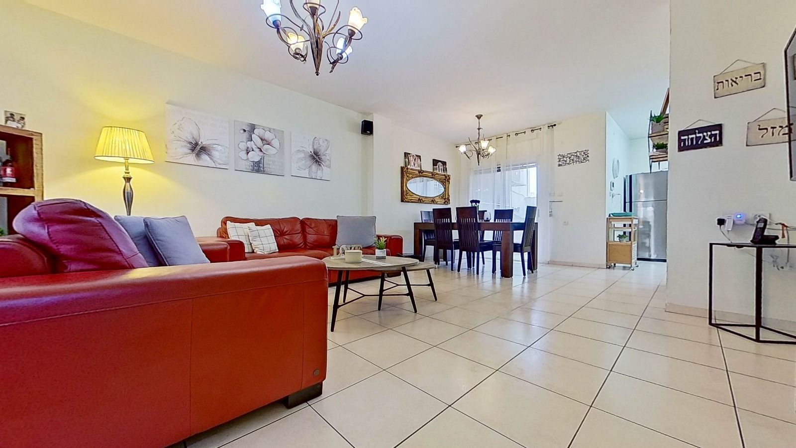 סלון עם ספה אדומה, שולחן ונברשת.