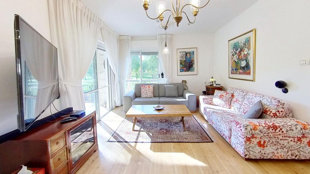 סלון מלא ברהיטים וטלוויזיה בעלת מסך שטוח.