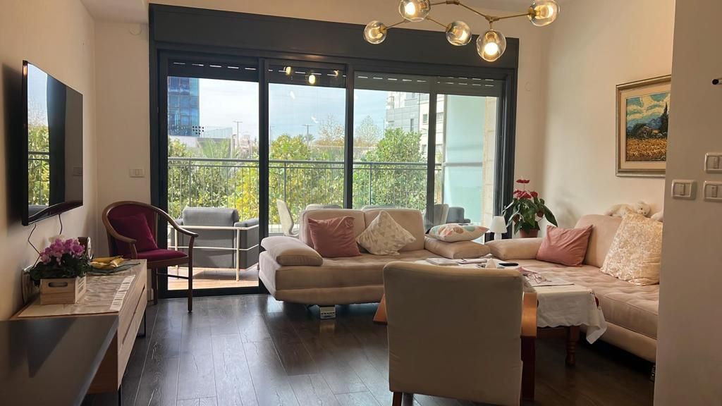 סלון מלא ברהיטים וטלוויזיה בעלת מסך שטוח.