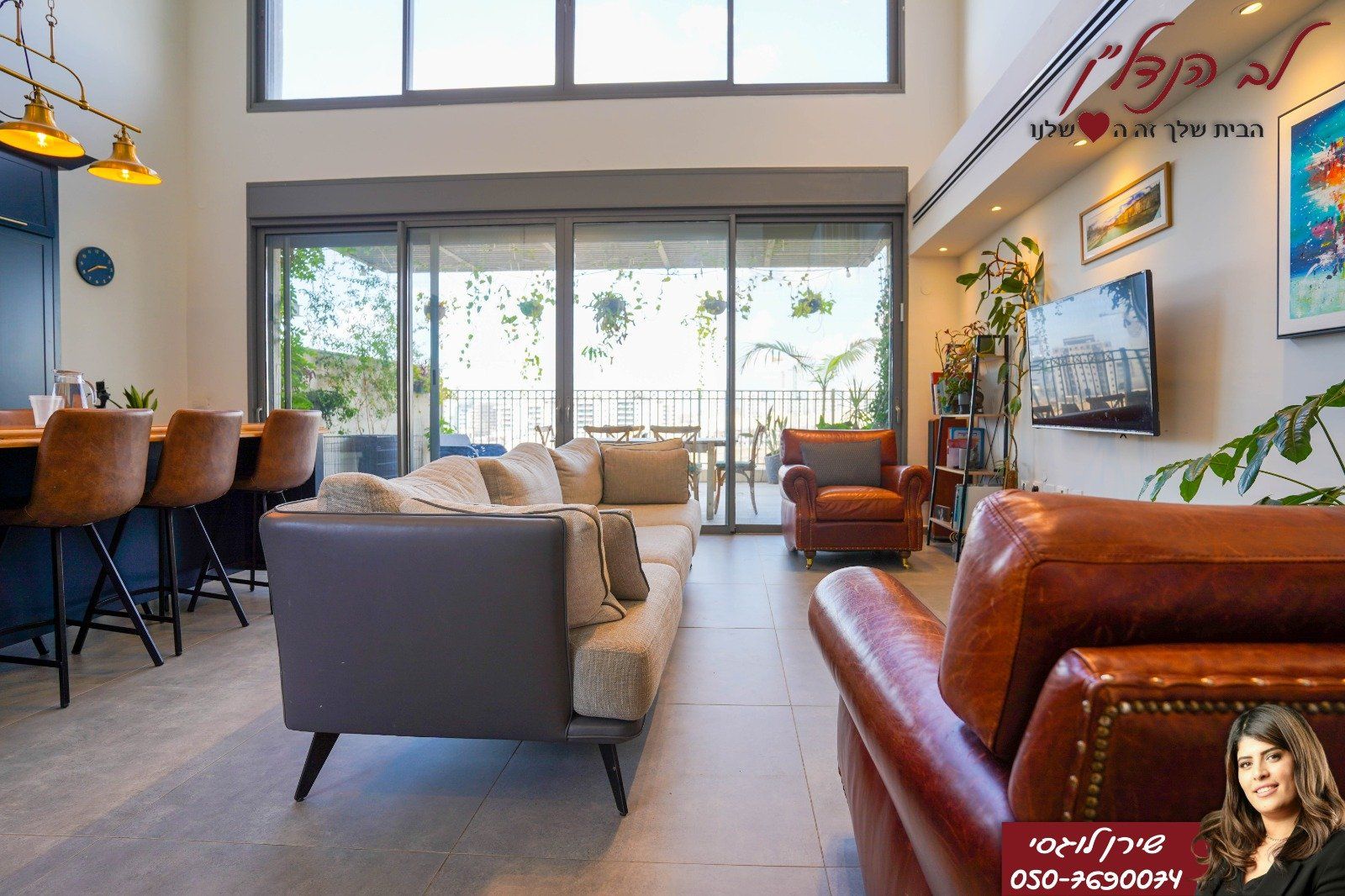 סלון עם ספה, כיסא, טלוויזיה ודלתות הזזה מזכוכית.