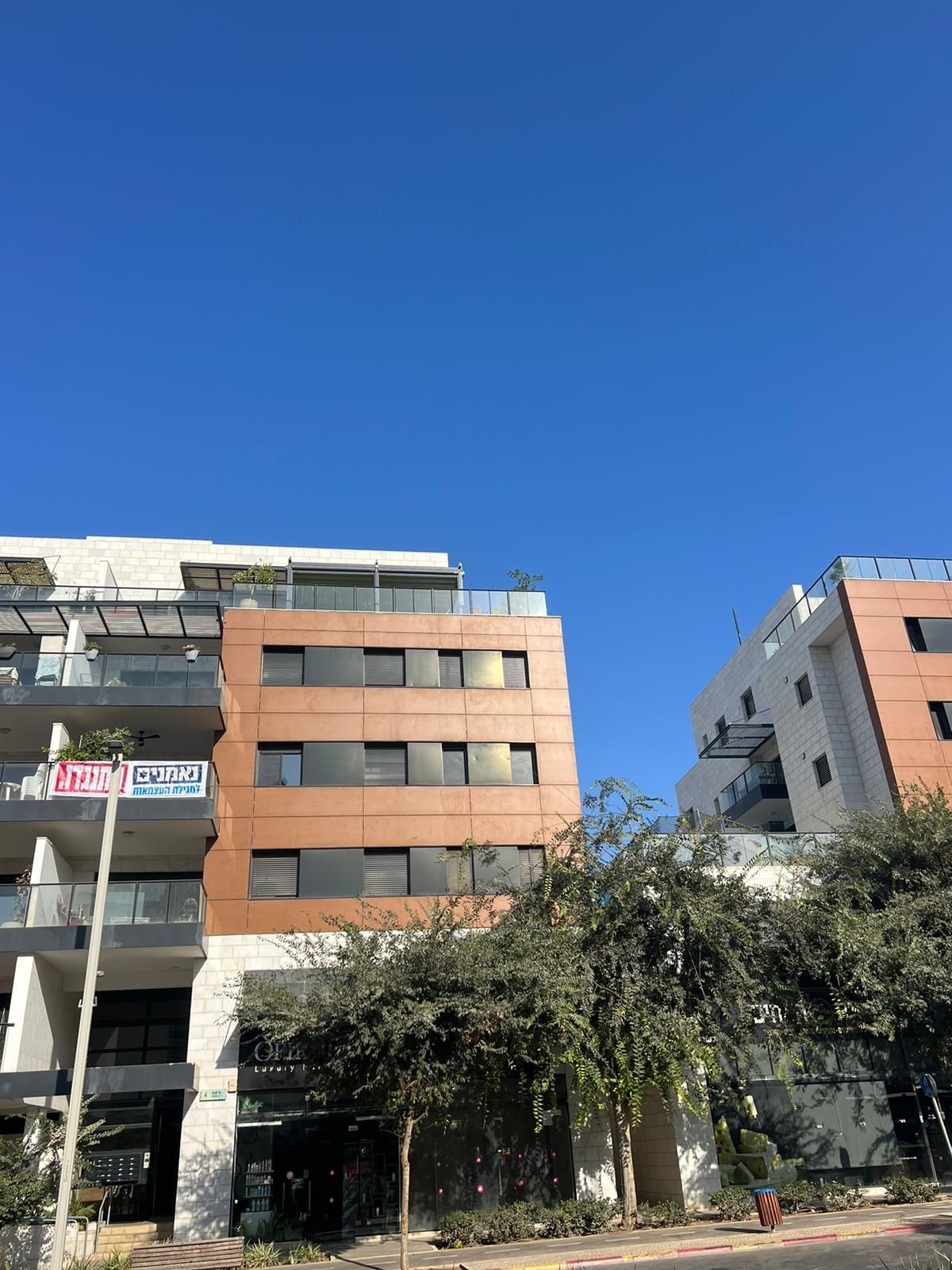 בניין דירות גדול עם שמיים כחולים ברקע